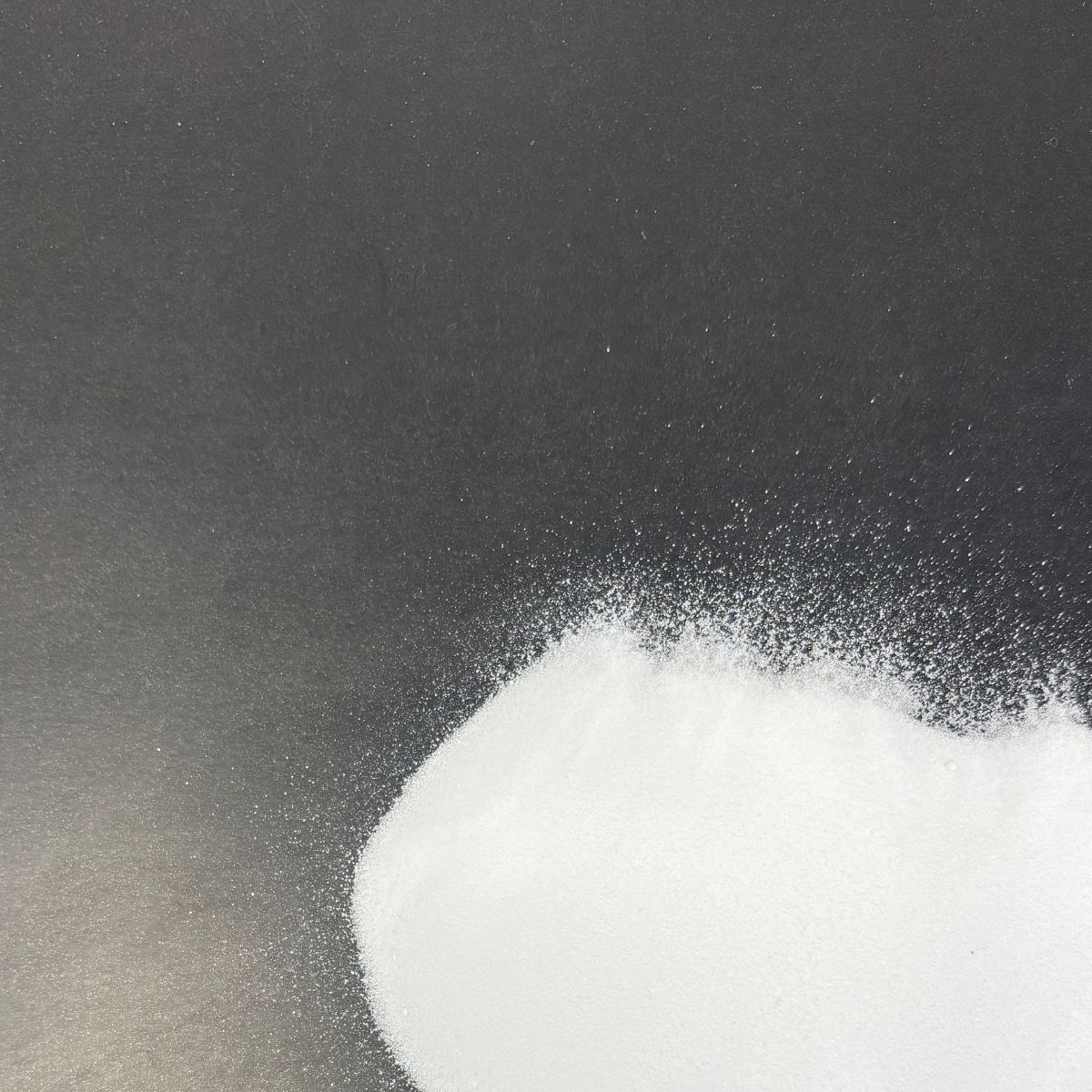 Weisses Natriumsulfat-Pulver auf dunkler Flaeche