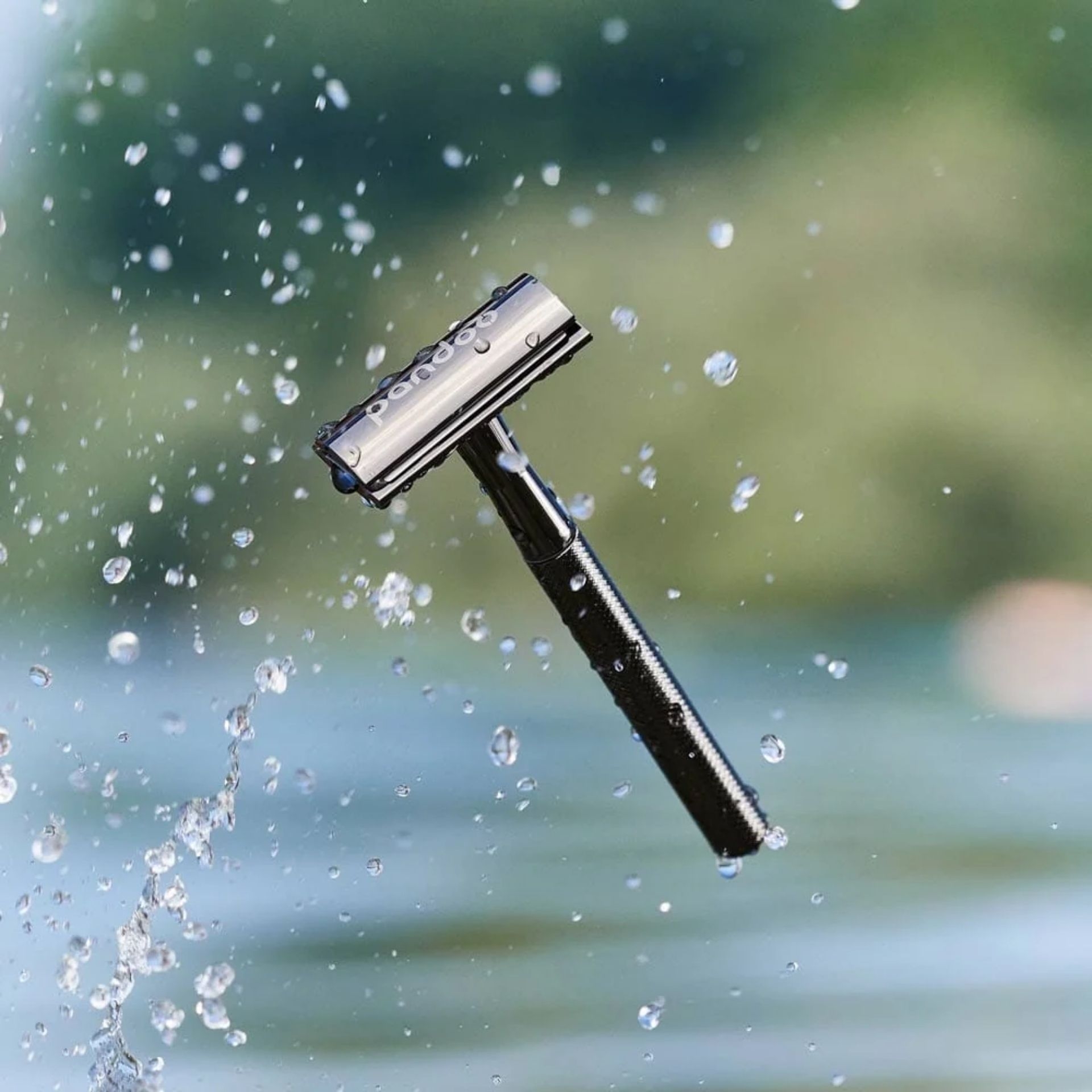 pandoo Rasierhobel Schwarz mit Wassertropfen vor unscharfem Hintergrund