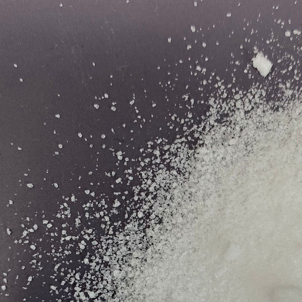 Kristallines Harnstoffpulver auf dunklem Untergrund verteilt