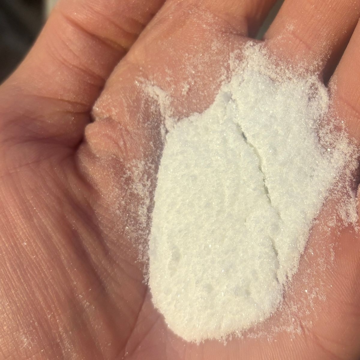 Weisse Ascorbinsaeure lose in einer geoeffneten Hand