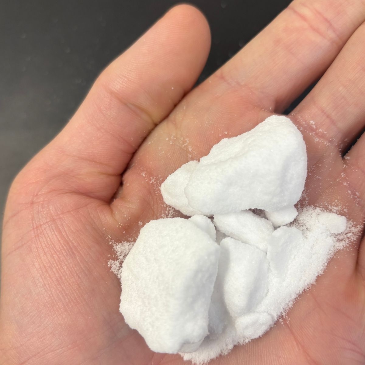 Kaliumchlorid-Pulver und Brocken in einer Hand