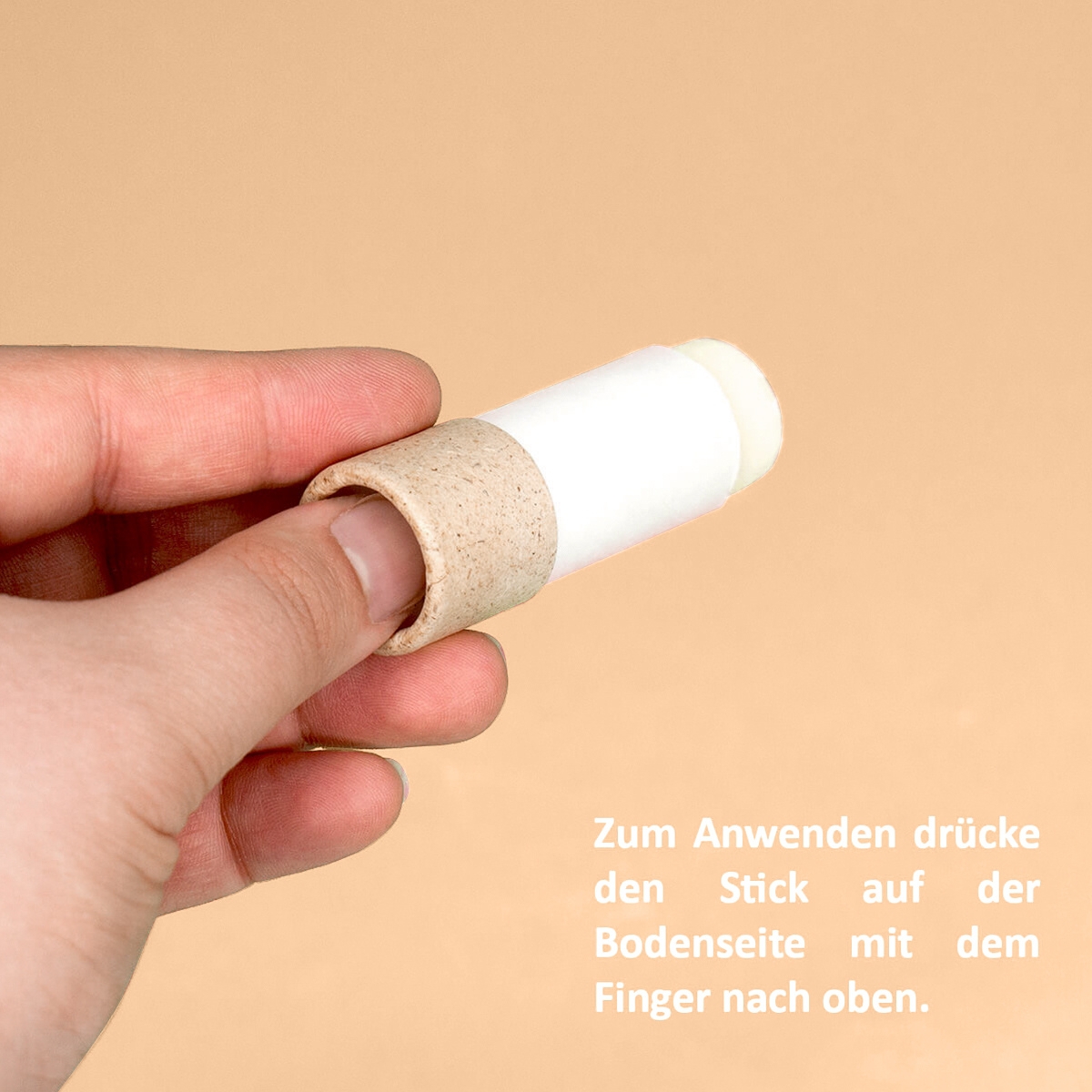 Hand drueckt den Lippenpflegestift Natural von Puremetics von unten nach oben zur Anwendung