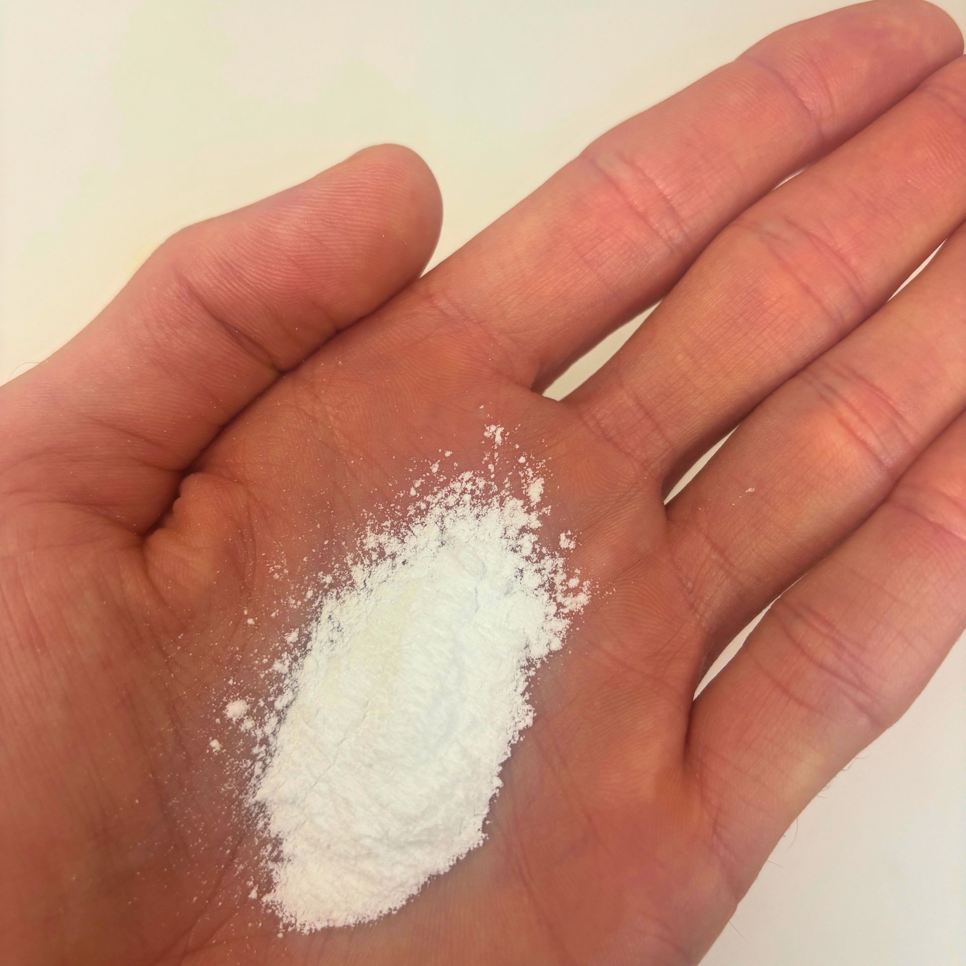 Feines weisses Magnesiumtaurat Pulver auf einer geoeffneten Hand als Detailaufnahme