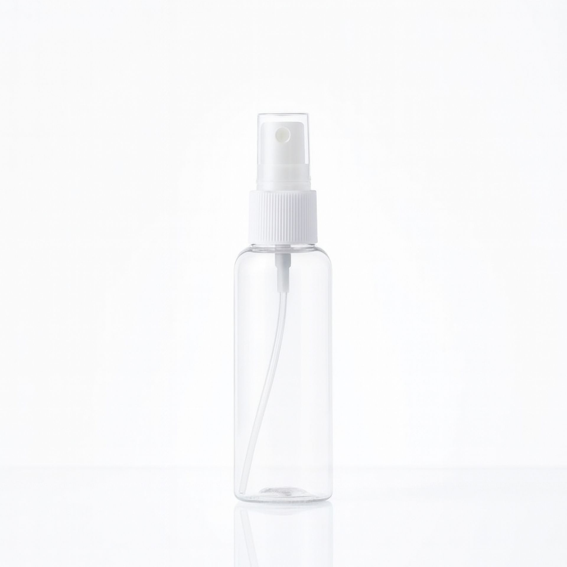 Transparente 100ml PET-Sprayflasche mit weissem Spruehkopf_ stehend auf heller Flaeche_ geeignet zum Befuellen mit Fluessigkeiten