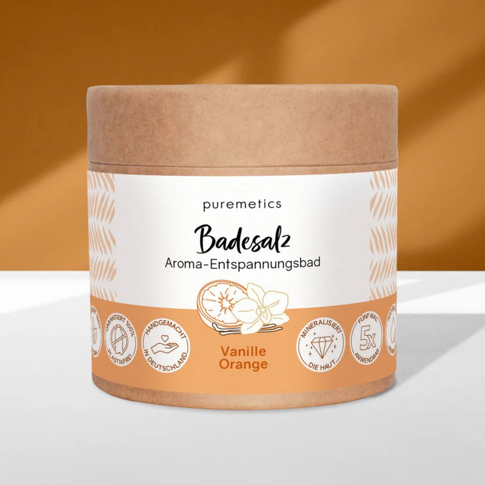 Puremetics Badesalz Vanille Orange in nachhaltiger Verpackung vor warmem Hintergrund