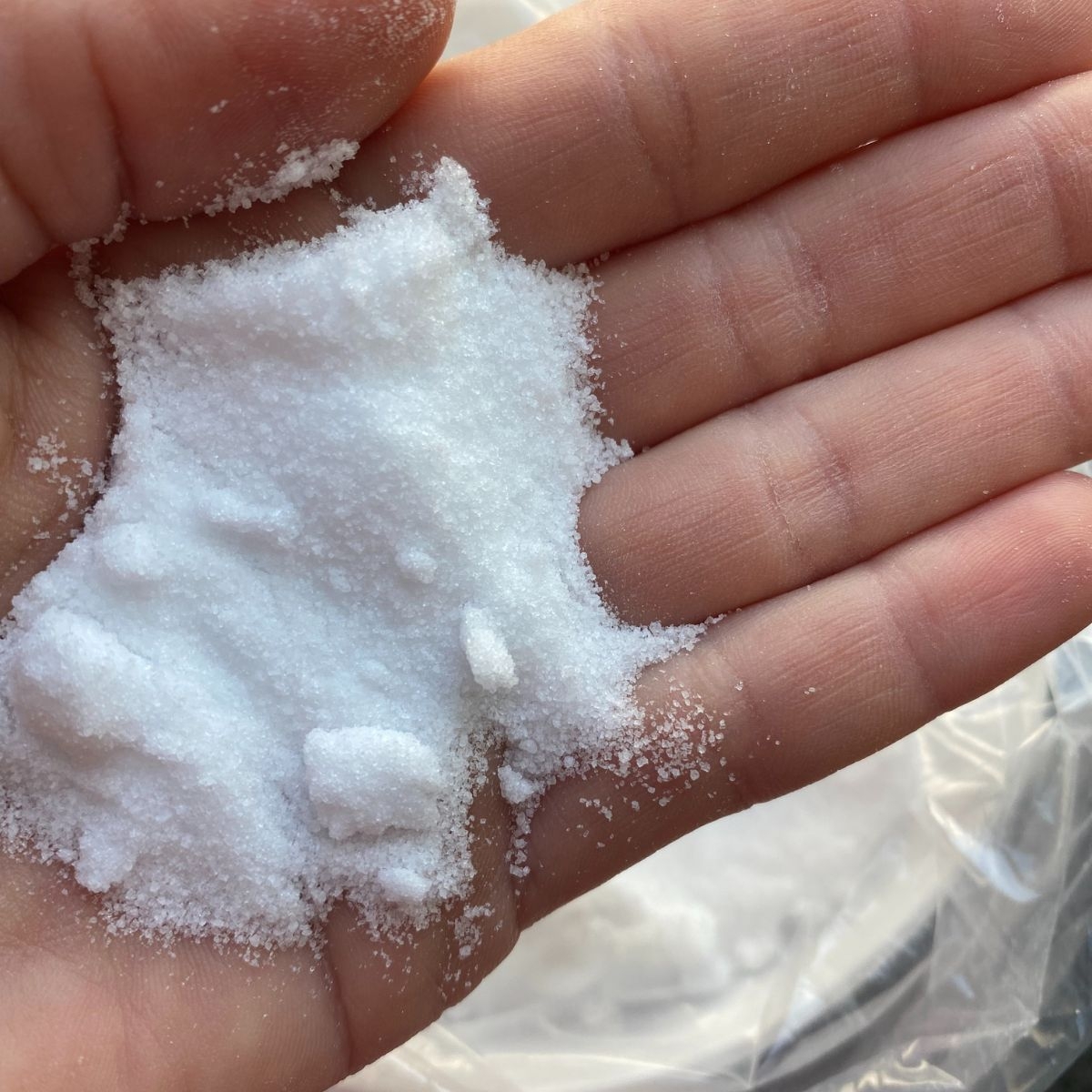 Harnstoff als weisses Pulver in einer Hand gehalten_ Nahaufnahme