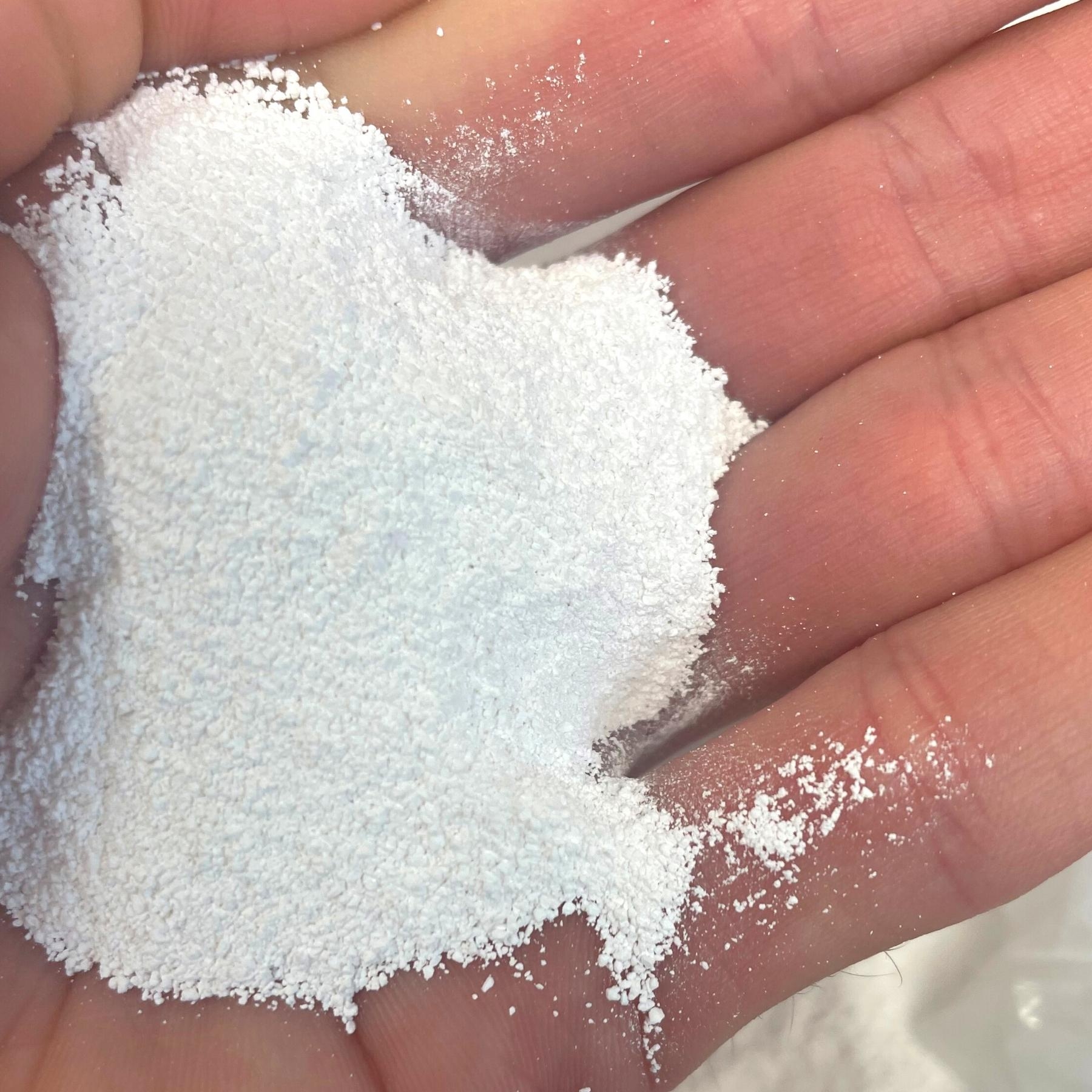 Weisse Magnesiumoxidpulverprobe auf einer Handflaeche