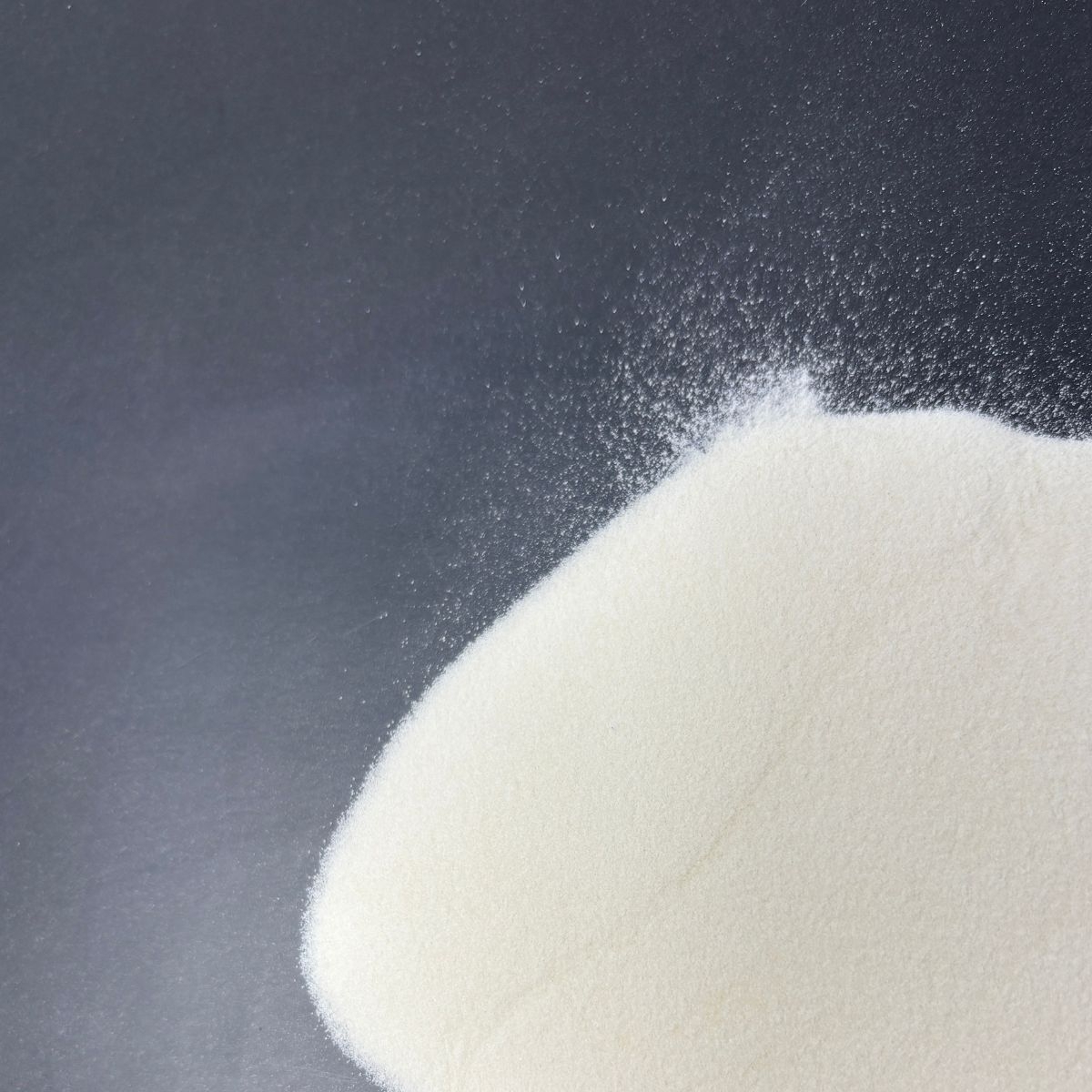 Feines weisses Xanthan Gum Pulver auf dunklem Untergrund verstreut