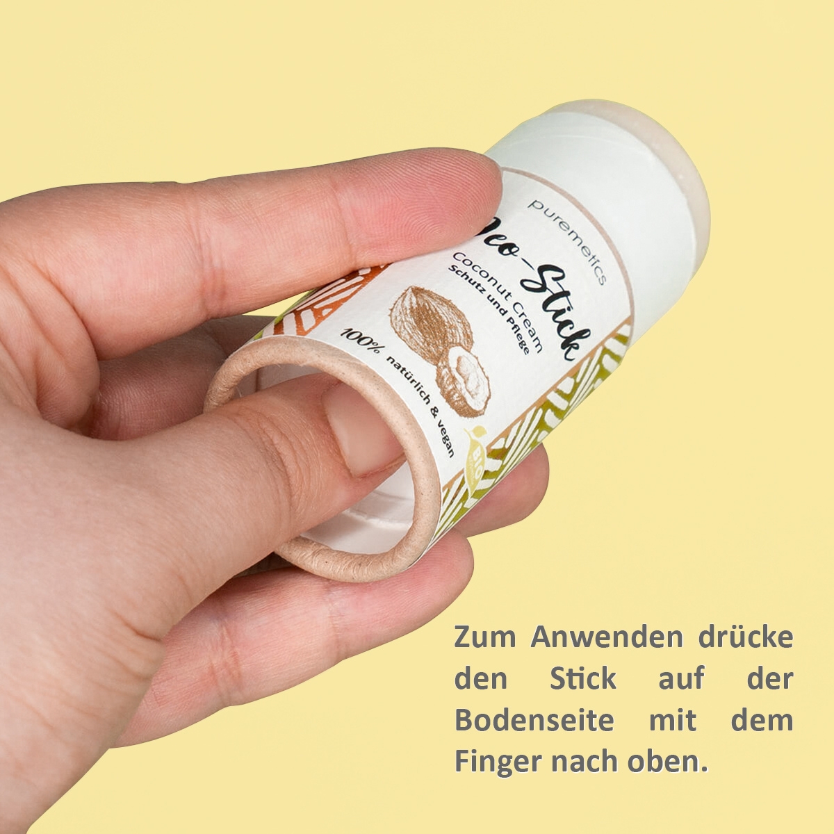 Hand drueckt Deo-Stick von puremetics von unten zum Anwenden nach oben