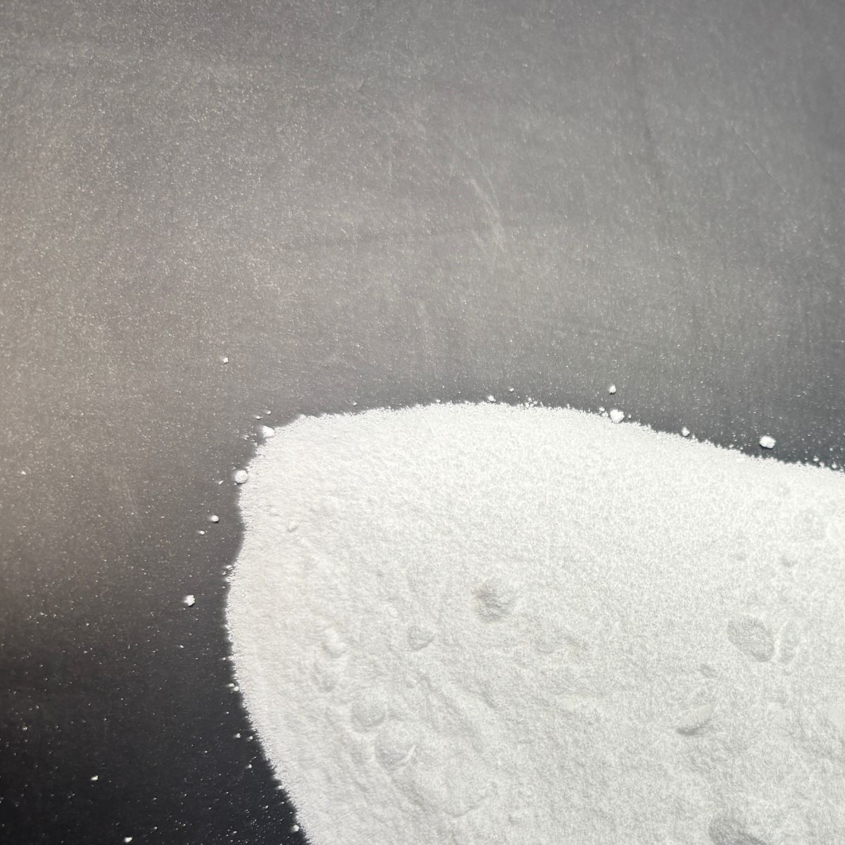 Weisses Waschsoda-Pulver auf dunklem Hintergrund verstreut