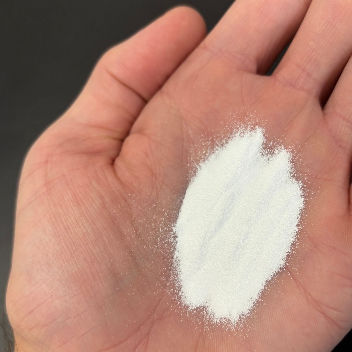 Weisses Magnesiumcitratpulver lose in einer geoeffneten Hand