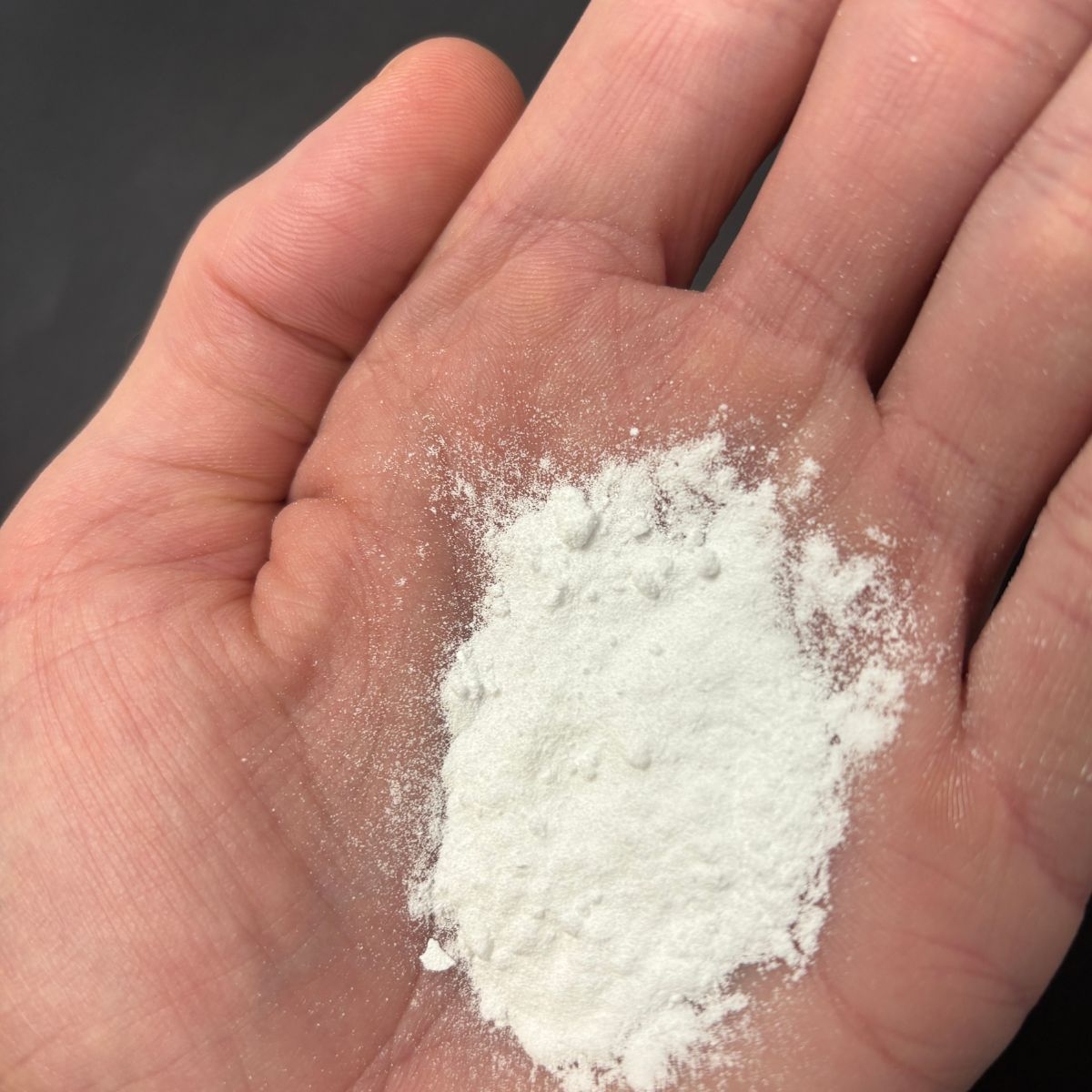 Waschsoda als feines weisses Pulver auf einer geoeffneten Handflaeche