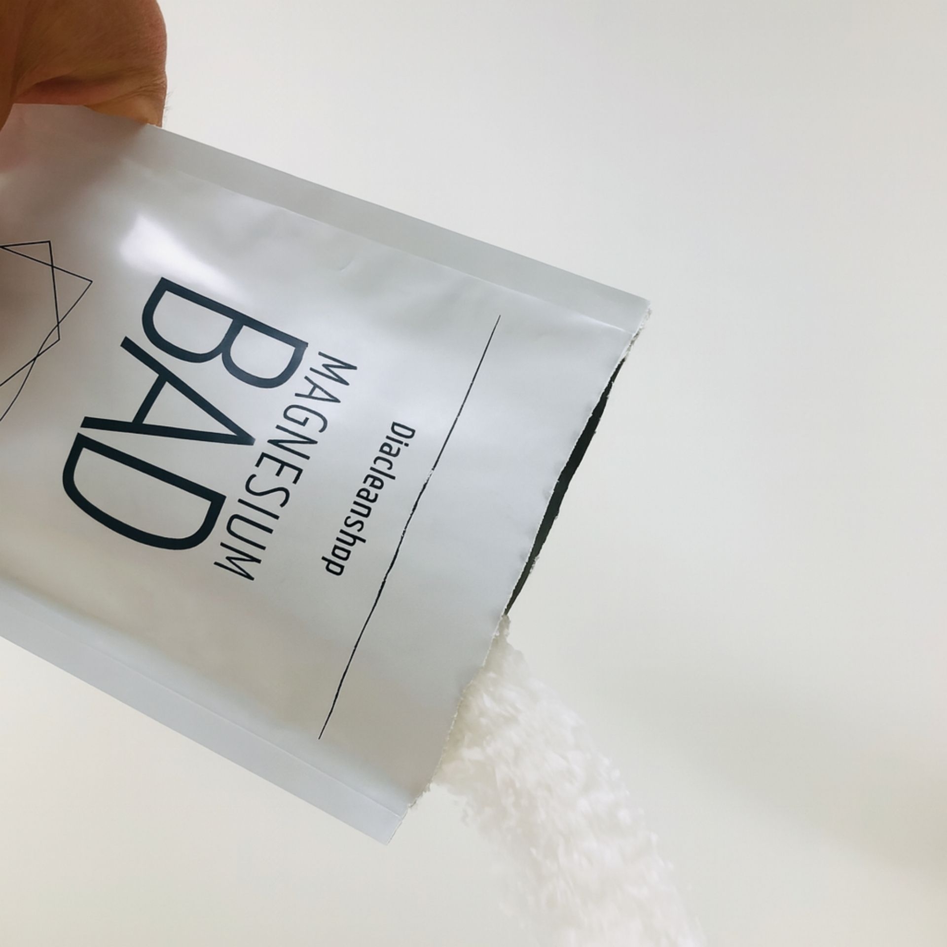 Geoeffneter Beutel Magnesiumbad 250g von Diacleanshop_ aus dem die weissen Kristalle herausgeschuettet werden