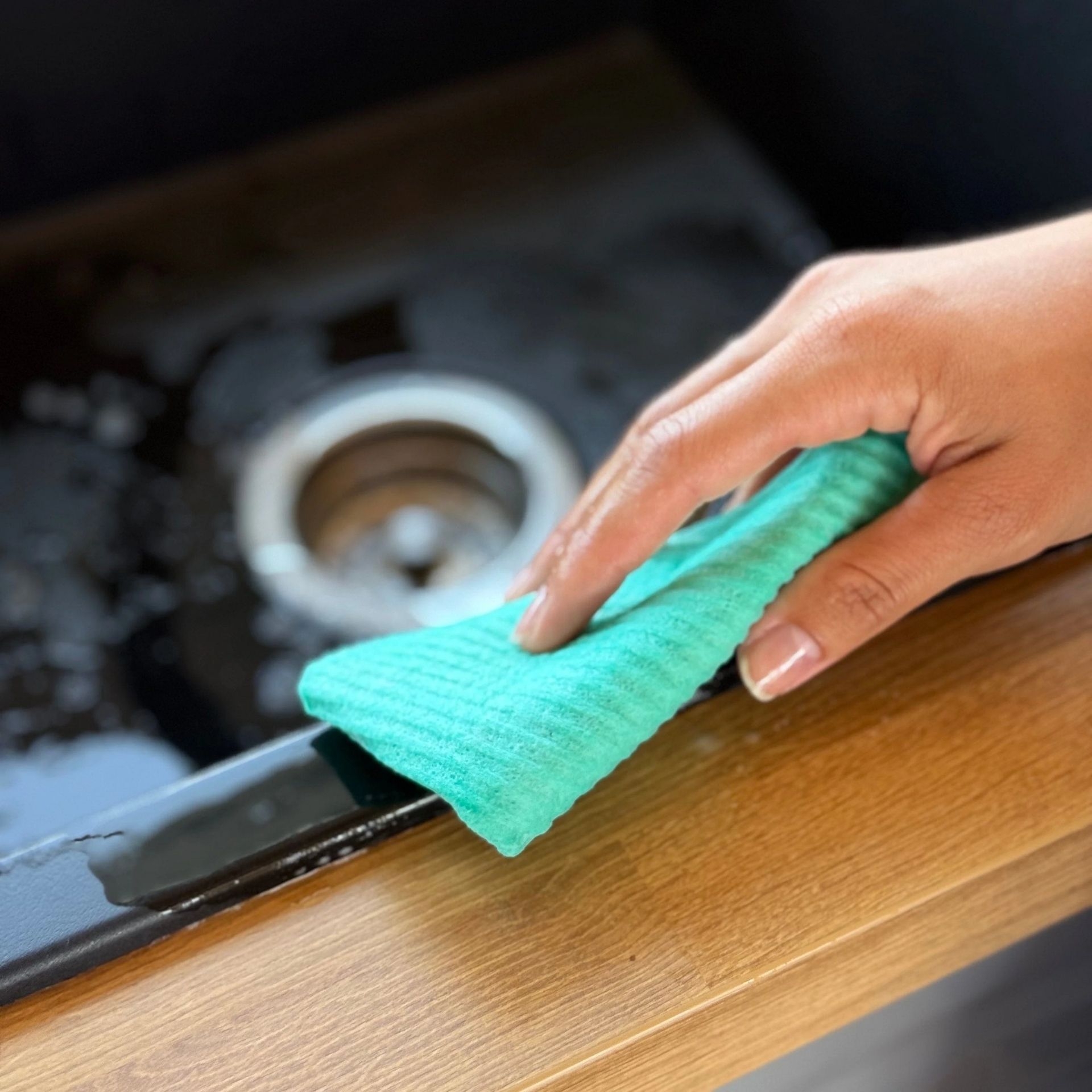pandoo Schwammtuch beim Aufwischen von Fluessigkeit auf einer Kuechenarbeitsflaeche