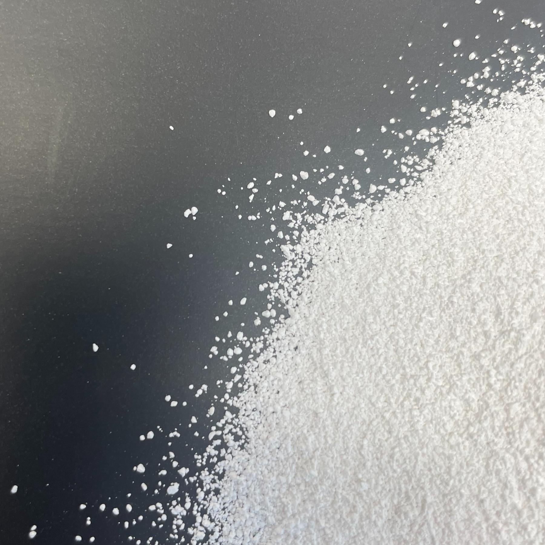 Weisses Magnesiumoxidpulver auf schwarzem Untergrund verteilt