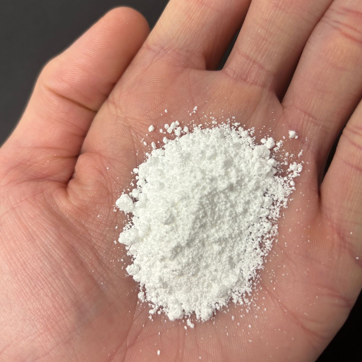 Magnesiumcarbonat Pulver in einer Hand von oben fotografiert